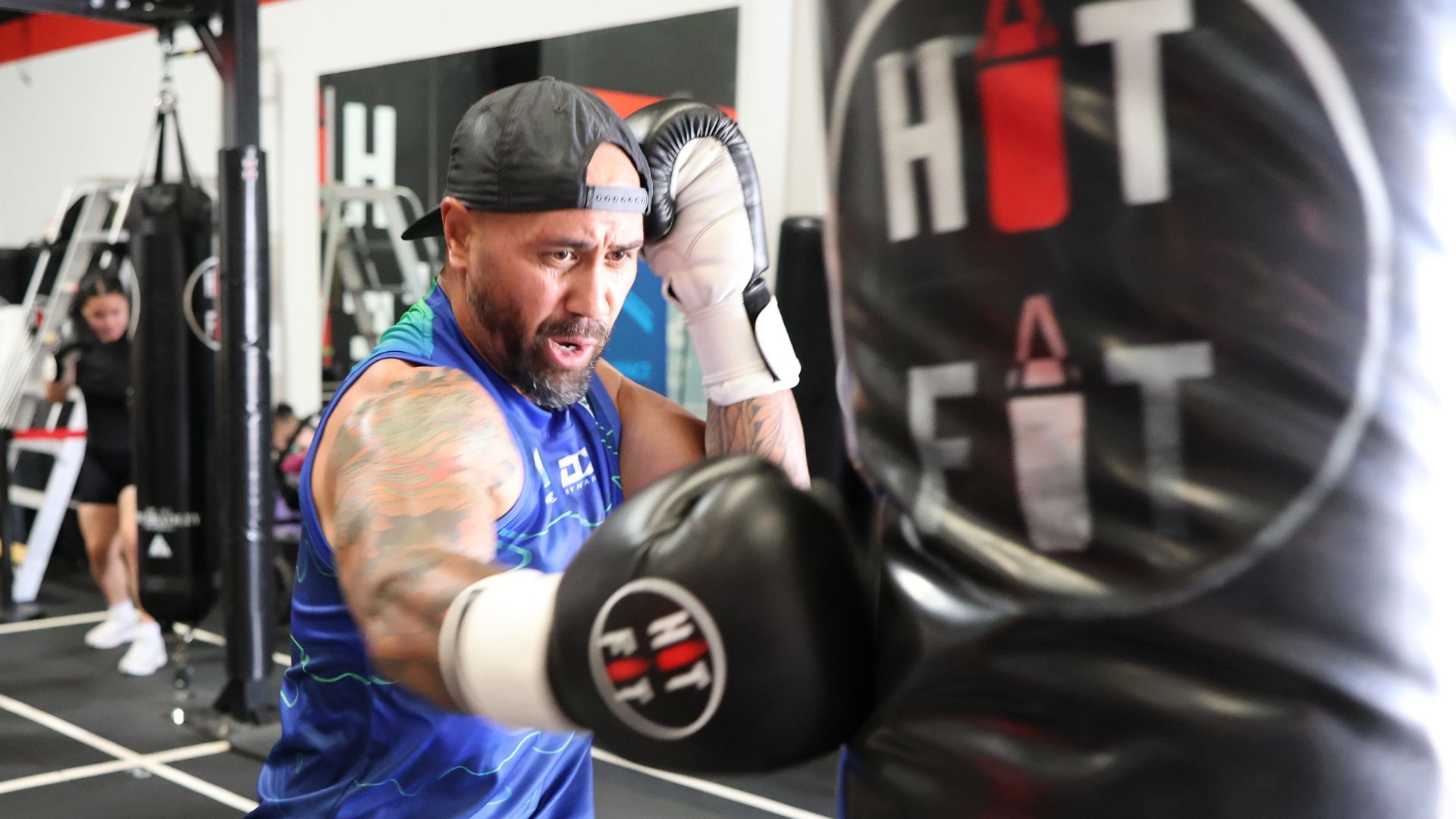 Coach leading a boxing class with CloudFit on screen