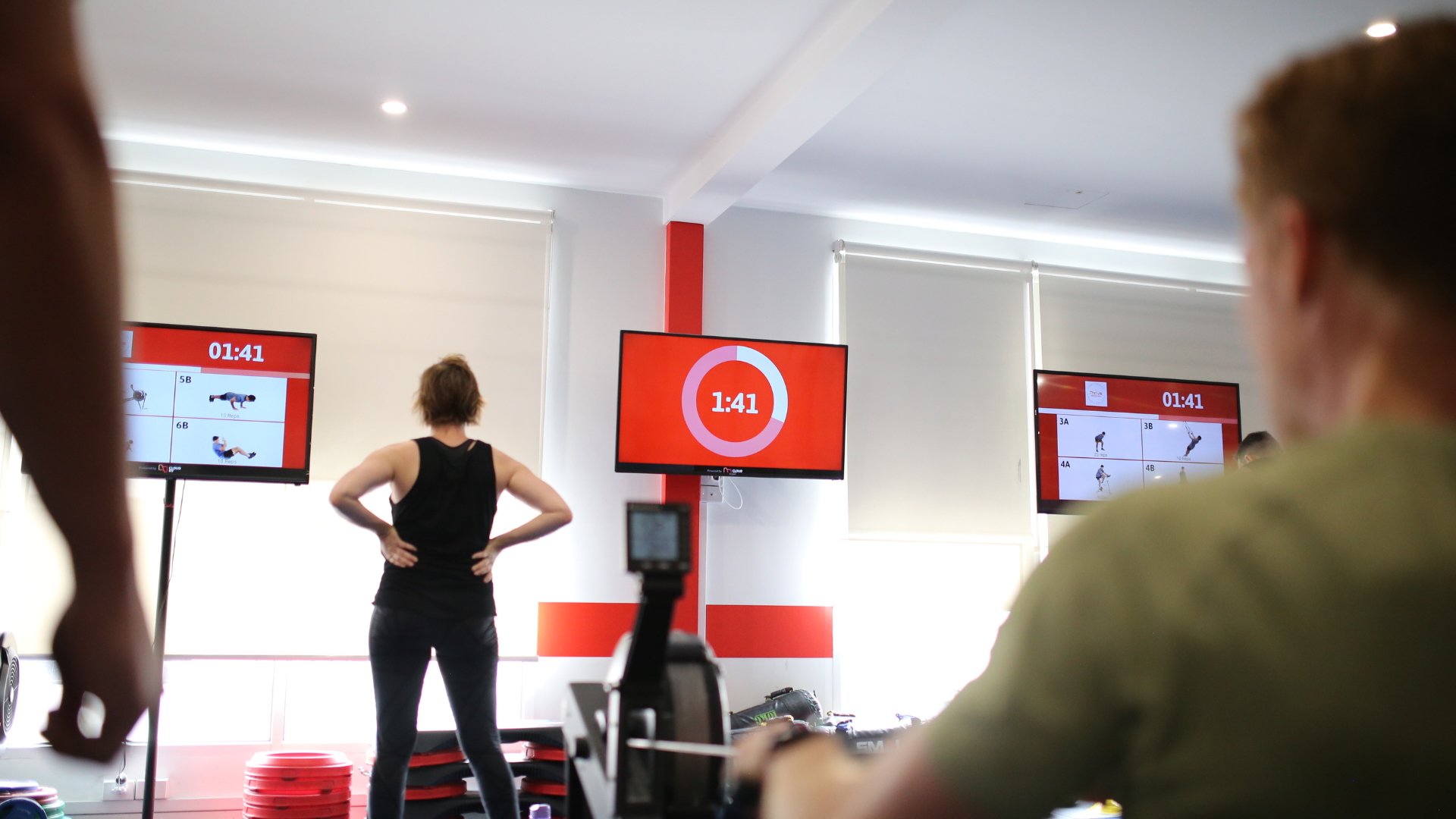 A gym with 3 TVs running CloudFit