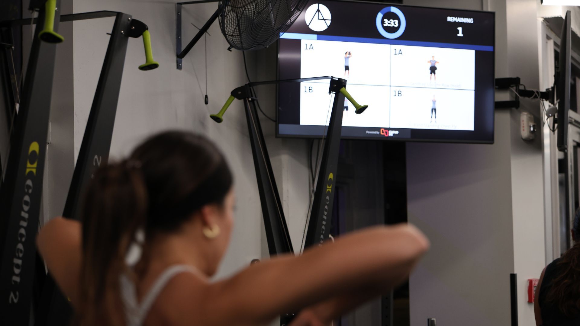 Coach leading a HIIT class with CloudFit on screen