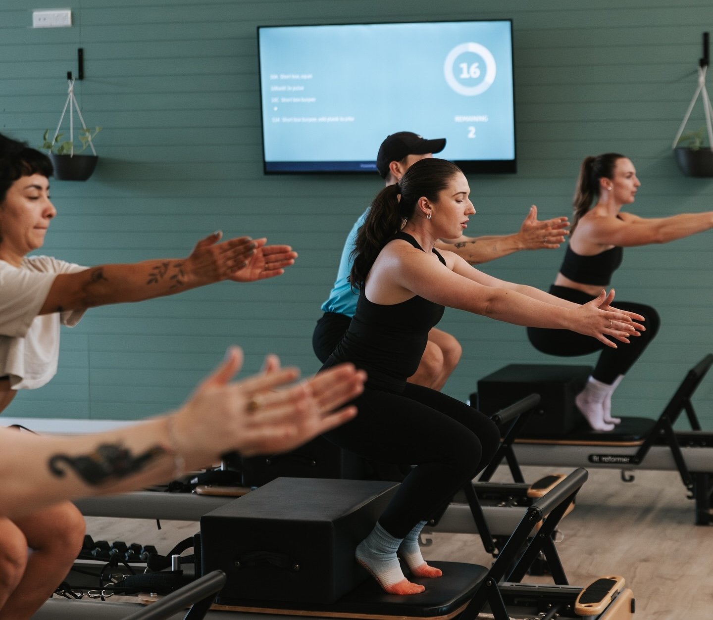 Instructor leading a Pilates class with CloudFit on screen